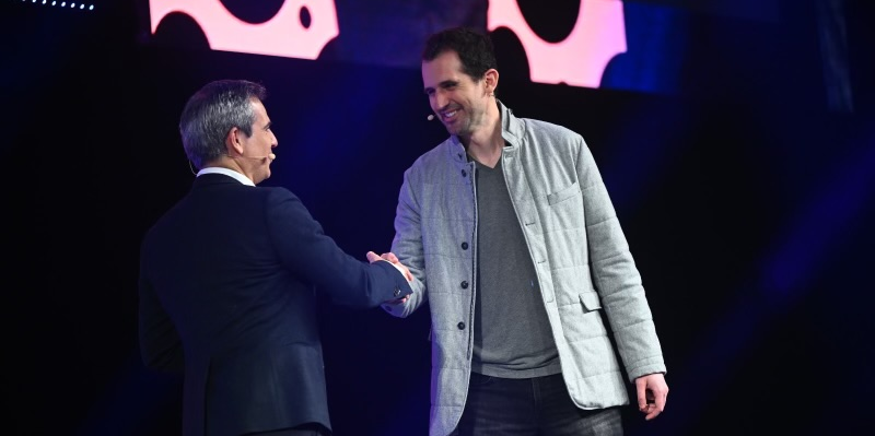Sur la scène du AWS Summit Paris 2024, le directeur général France et Europe du sud d'AWS Julien Groues (à gauche) accueillait le cofondateur et CTO d'Anthropic Tom Brown (à droite).