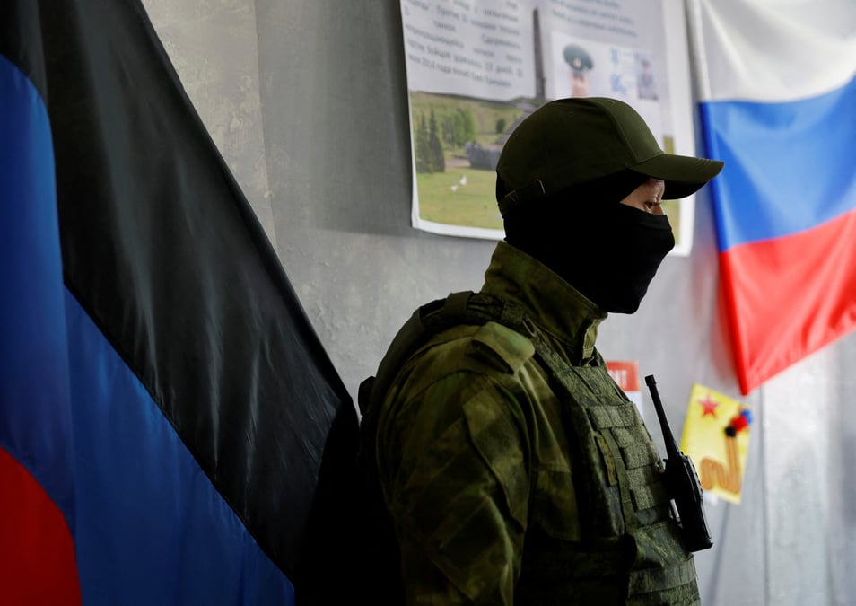 Un membre du service de la republique populaire autoproclamee de donetsk monte la garde dans un bureau de vote avant le referendum prevu a donetsk