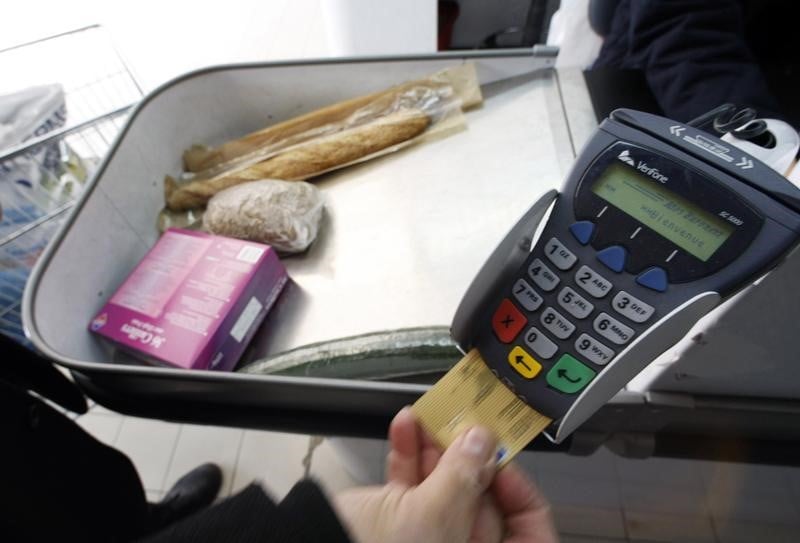 A shopper pays with his credit card in a supermarket in nice