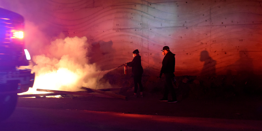 A Minneapolis, les tensions restent vives. Ici, une personne tente d'éteindre un feu.