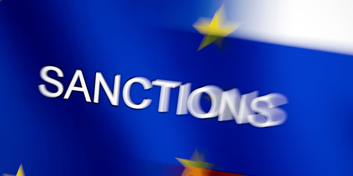 Le mot "sanctions" est affiche sur les drapeaux de l'ue et de la russie
