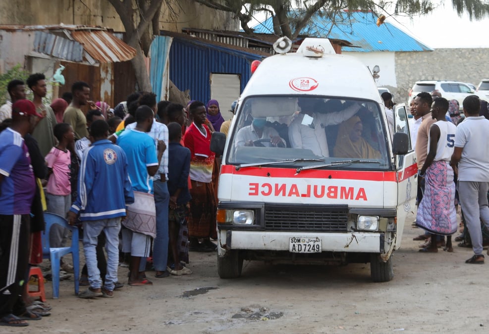Des personnes se rassemblent alors qu'une ambulance transporte le corps d'une femme non identifiee tuee dans une explosion qui s'est produite alors que des fetards se baignaient sur la plage du lido a mogadiscio