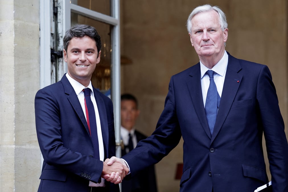Le nouveau premier ministre michel barnier serre la main du premier ministre sortant gabriel attal lors de la ceremonie de passation des pouvoirs a l'hotel matignon a paris