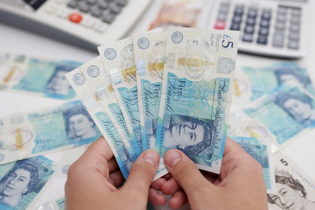 Une femme tient des billets de livres sterling