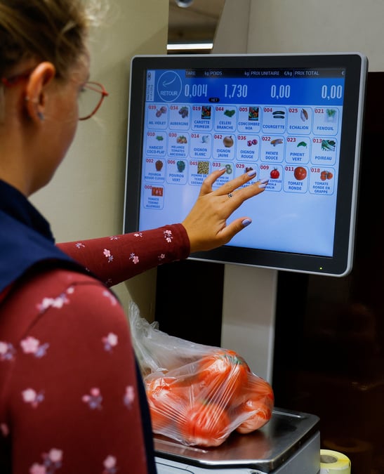 Un employe pese des legumes dans un supermarche de nice