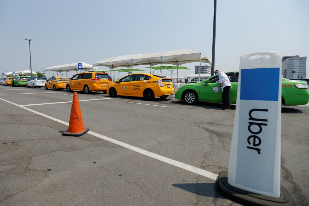 Des taxis font la queue a cote d'une zone de ramassage uber