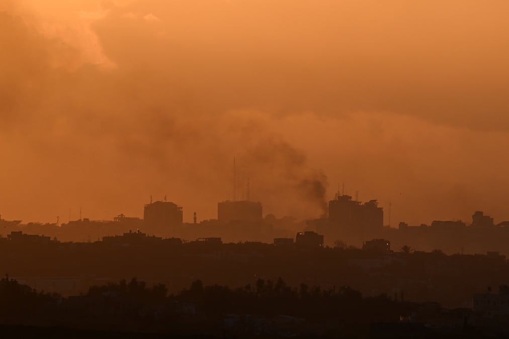 De la fumee s'eleve de gaza, alors que le soleil se couche, vue de sderot