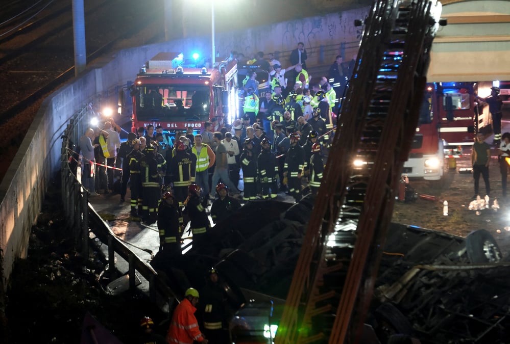 Des pompiers et du personnel de secours travaillent apres qu'un car transportant des touristes a chute d'un pont situe en peripherie de venise
