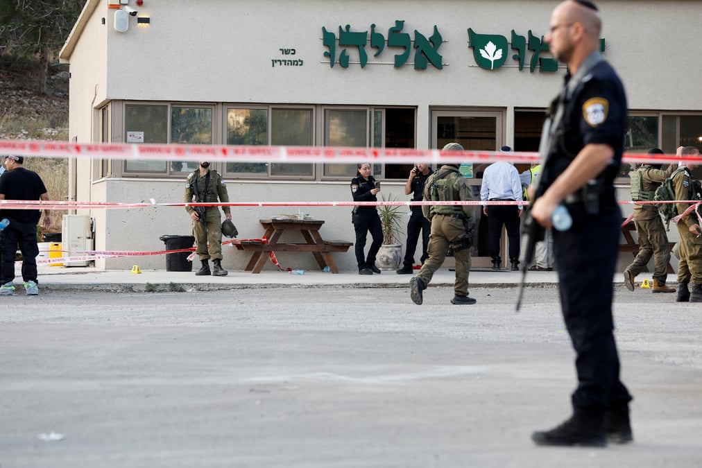 Le personnel de securite travaille sur les lieux d'une attaque menee par deux palestiniens qui a tue quatre personne pres d'une colonie de peuplement juif en cisjordanie occupee
