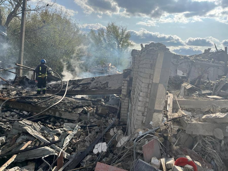 Des pompiers travaillent sur le site d'une frappe militaire russe, dans le village de groza