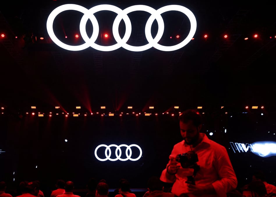A man walks past a logo of german automobile manufacturer audi ahead of the launch of the audi q8 e-tron and the audi q8 sportback e-tron electric suvs in mumbai