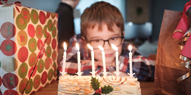 Un enfant devant une bûche de Noël