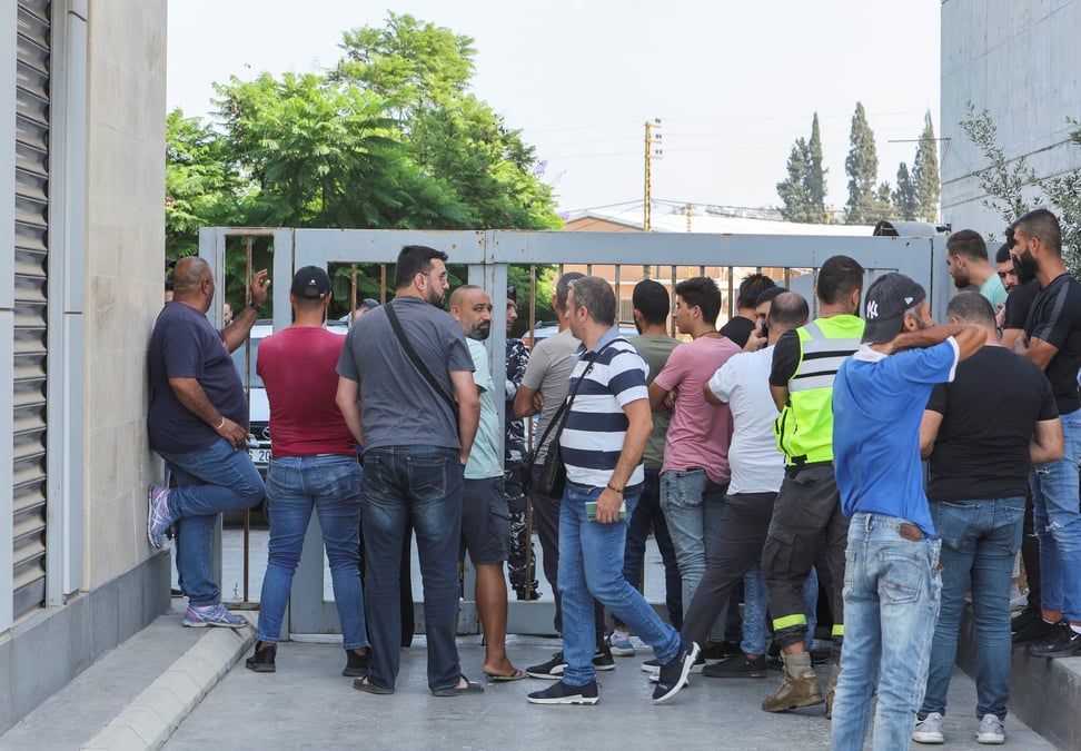 Des personnes se rassemblent devant une agence de byblos bank