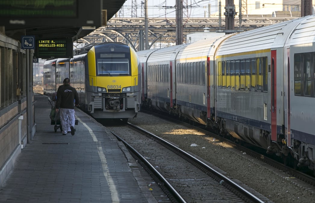 Un travailleur marche sur le quai d'une gare