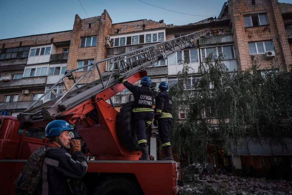 Des sauveteurs travaillent sur le site ou un batiment a ete detruit lors d'une frappe de missile russe, a pokrovsk