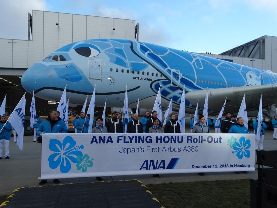 Les peintres (en blouson bleu) présentent la nouvelle livrée de l'A380 de ANA.