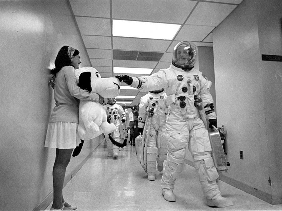Tom Stafford touche le nez de Snoopy entre les mains de Jamye Flower-Coplin, la secrétaire de l'astronaute Gordo Cooper