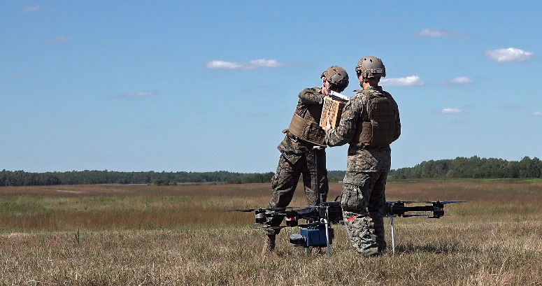 Deux soldats récupèrent le colis embarqué sur le drone.