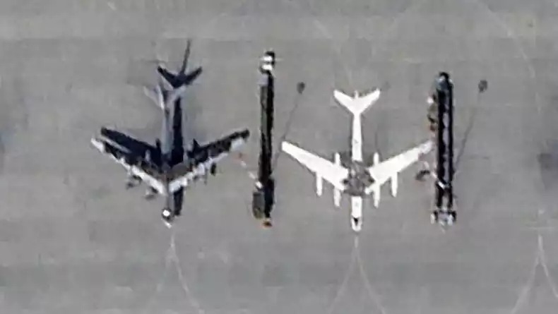 Un bombardier stratégique Tu-95 russe à côté d'une peinture au sol d'un Tu-95 sur la base aérienne d'Engels-2.