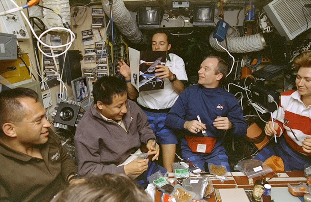 L'équipage “assis” autour de la table à manger du module de base de Mir.