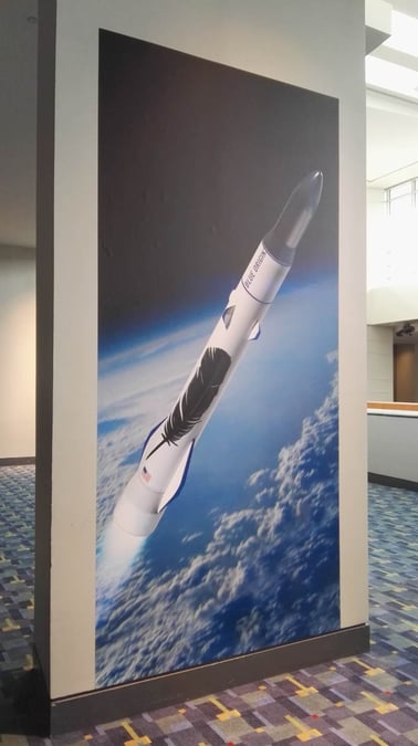 A la sortie de la conférence, de larges posters du New Glenn bi-étage recouvraient les murs du lobby du centre de conférences.