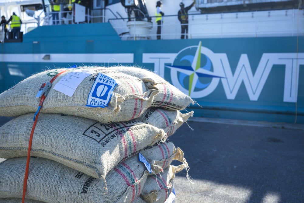 Des sacs de café sont déchargés depuis un navire de la compagnie TOWT sur les quais du Havre