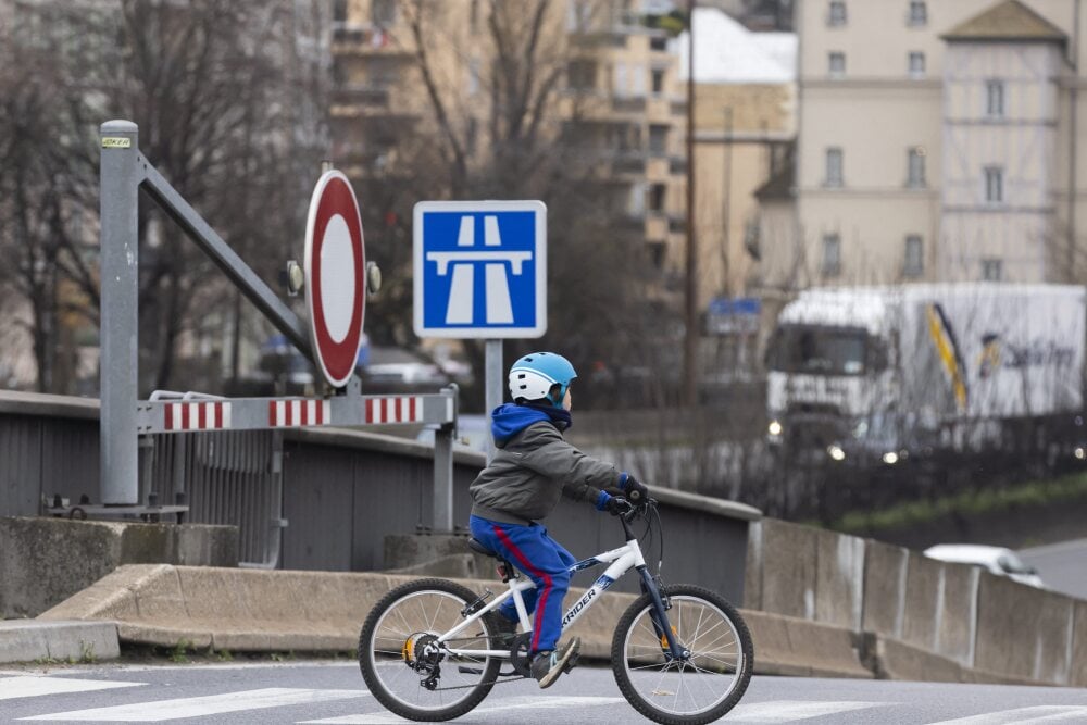 Vincent Isore/IP3 ; Charenton-le-Pont, France February 23, 2022 - A child rides his bike next to an entrance on the A4 freeway POLLUTION, ATMOSPHERIQUE, ILLUSTRATION, VOITURES, AUTOMOBILES, PERIPHERIQUE, AUTOROUTE URBAINE, VILLE, REGION PARISIENNE,...
