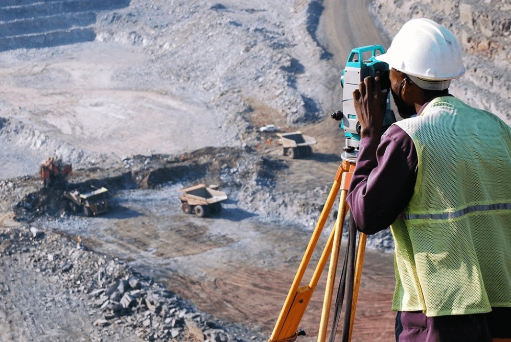 Géomètre utilisant un théodolite sur un site minier