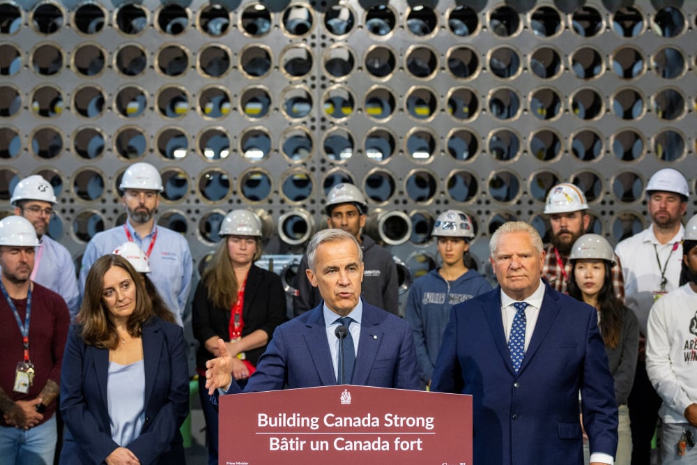 Le Premier ministre canadien Mark Carney s'exprime devant Nicolle Butcher, présidente-directrice générale d'Ontario Power Generation (OPG), et Doug Ford, Premier ministre de l'Ontario, lors d'une conférence de presse devant une maquette de réacteur sur...