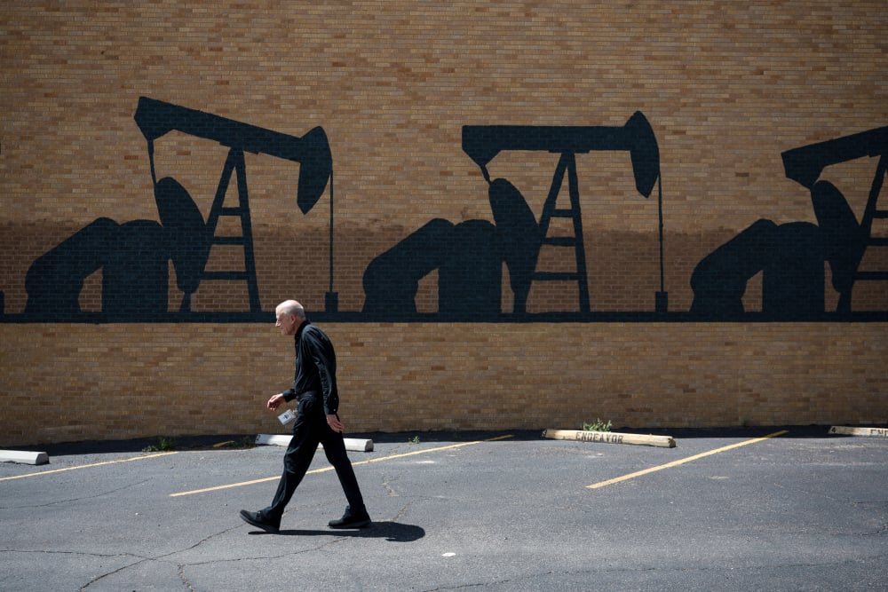 Otis Bass, ingénieur technicien senior en forage chez Diamondback Energy, passe devant une fresque représentant un chevalet de pompage à Midland, au Texas.