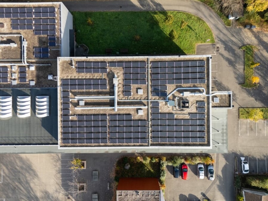 Vue aérienne de panneaux photovoltaïques installés sur le toit d'une école à Lyon.