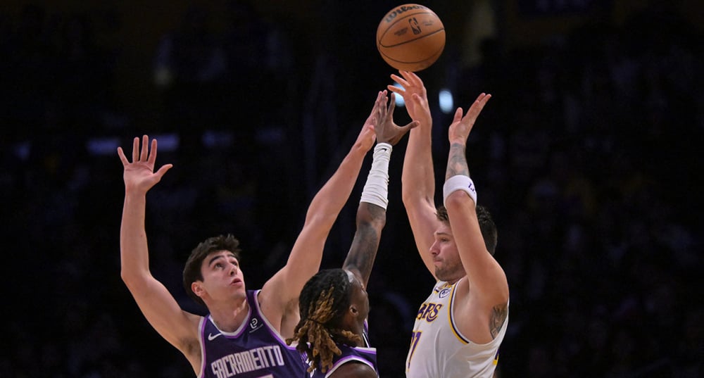 Maxime Raynaud et Keon Ellis des Sacramento Kings défendent sur Luka Dončić des Los Angeles Lakers lors de la première mi-temps au Crypto.com Arena, le 28 décembre 2025.