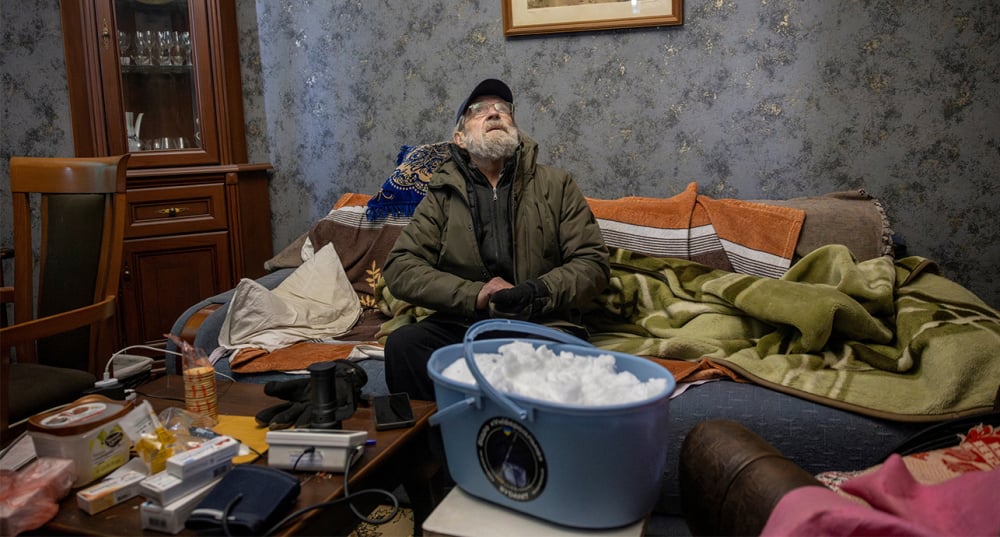 Après des frappes russes, Sergiy Przhistovskiy a perdu l'accès à l'eau courante. Assis dans son salon, l'Ukrainien attend la nuit pour faire fondre un seau plein de neige.