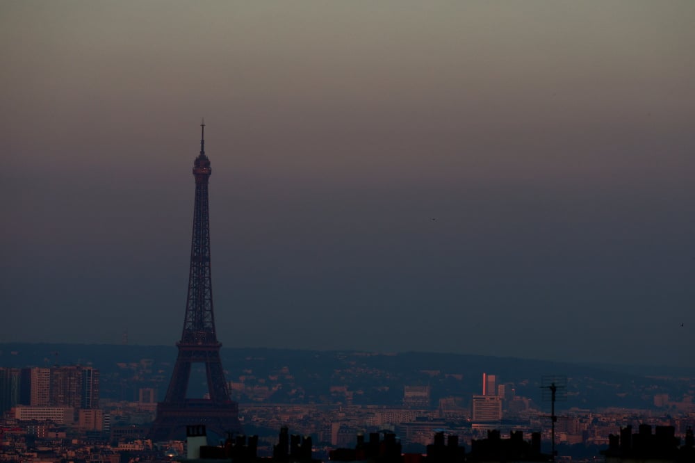 La tour Eiffel entourée d'un voile de particules fines surplombant la ligne d'horizon de Paris, France, le 26 juin 2024.