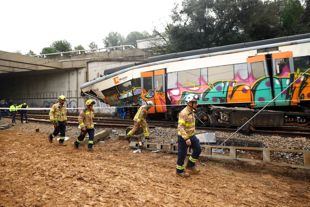 Des pompiers sur le site où un train régional est entré en collision avec un mur effondré entre Sant Sadurni d'Anoia et Gelida, près de Barcelone, le 21 janvier 2026 en Espagne.