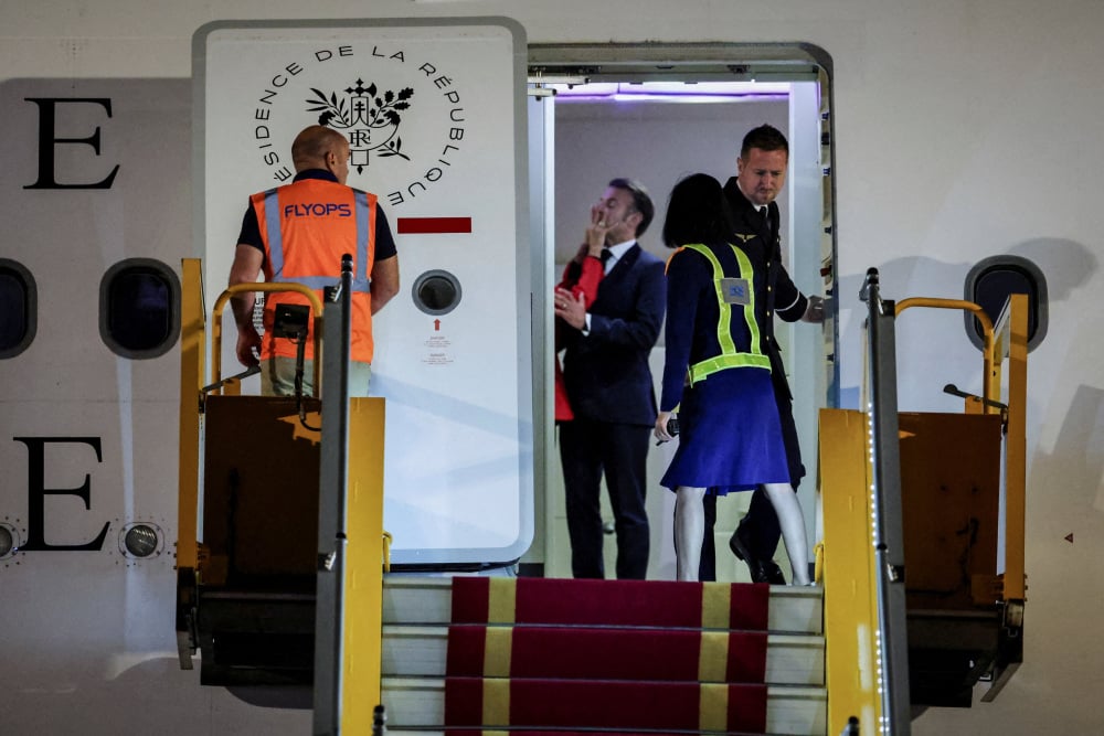 Le président français Emmanuel Macron et son épouse Brigitte Macron à leur arrivée au Vietnam pour entamer une tournée en Asie du Sud-Est, à l'aéroport international de Noi Bai, à Hanoï, le 25 mai 2025.