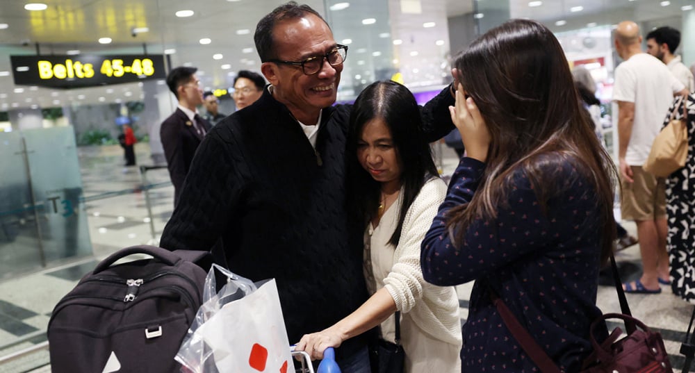 Un résidant de Dubaï, est accueillie par sa famille à son arrivée à l'aéroport de Changi à Singapour, le 7 mars 2026, à bord d'un vol de rapatriement en provenance du Moyen-Orient.