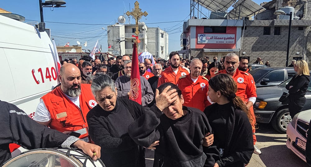 Des personnes en deuil assistent aux funérailles de Youssef Assaf, un volontaire de la Croix-Rouge libanaise tué lors d'une mission de sauvetage dans le sud du Liban, à Tyr, le 11 mars 2026.