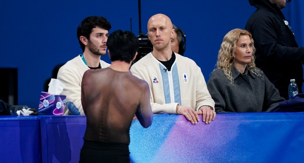 Benoît Richaud (au centre) aux Jeux de Milan-Cortina, lors du programme court de Adam Siao Him Fa (de dos), le 10 février.