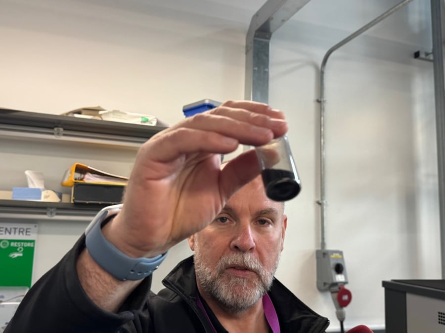 Ivan Buckley, directeur du Graphene Engineering Innovation Centre, montrant une fiole d'oxyde de graphène.