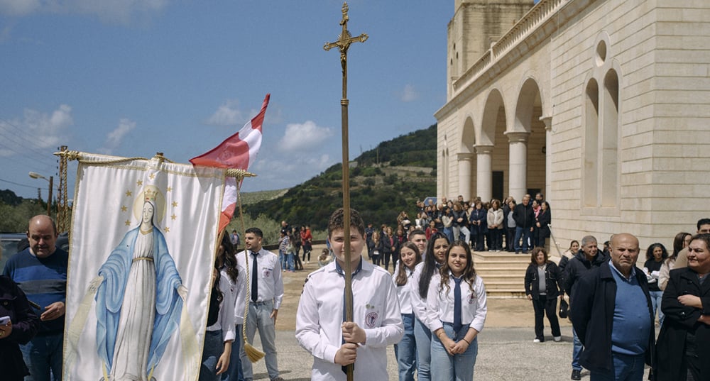Les habitants du village de Hajjeh devant l'Église de la Sainte Famille accueille le nonce apostolique monseigneur Paolo Borgia, archevêque et diplomate du Vatican lors d un convoi humanitaire organise au sud du Liban, le 30 mars.