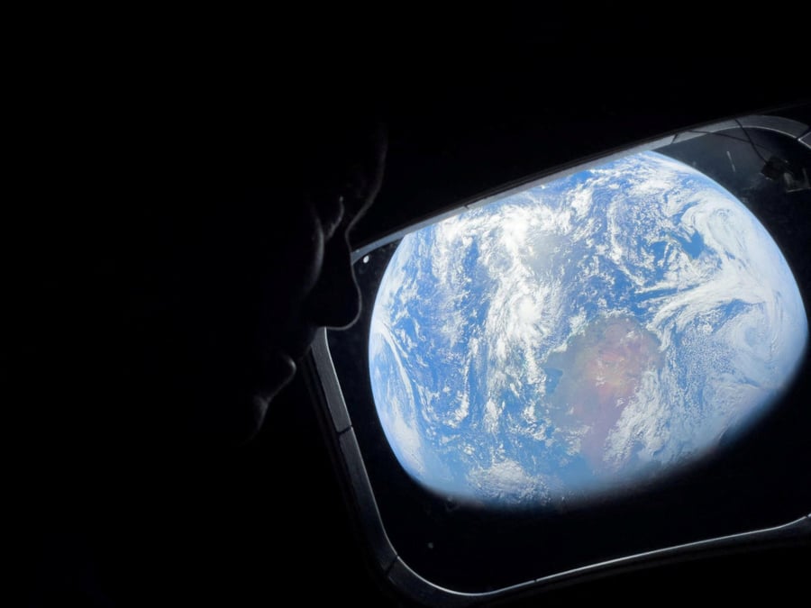 L'astronaute de la NASA et commandant d'Artemis II, Reid Wiseman, scrute par l'un des hublots principaux de la cabine du vaisseau spatial Orion, contemplant la Terre alors que l'équipage fait route vers la Lune, le 2 avril 2024.
