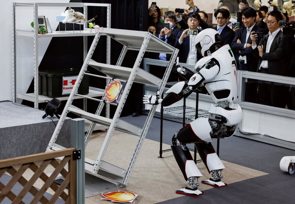 La plateforme humanoïde robuste « Kaleido 9 » de Kawasaki Heavy Industries soulève une étagère renversée lors d'une démonstration le premier jour du Salon international de la robotique, au Tokyo Big Sight, en décembre 2025.