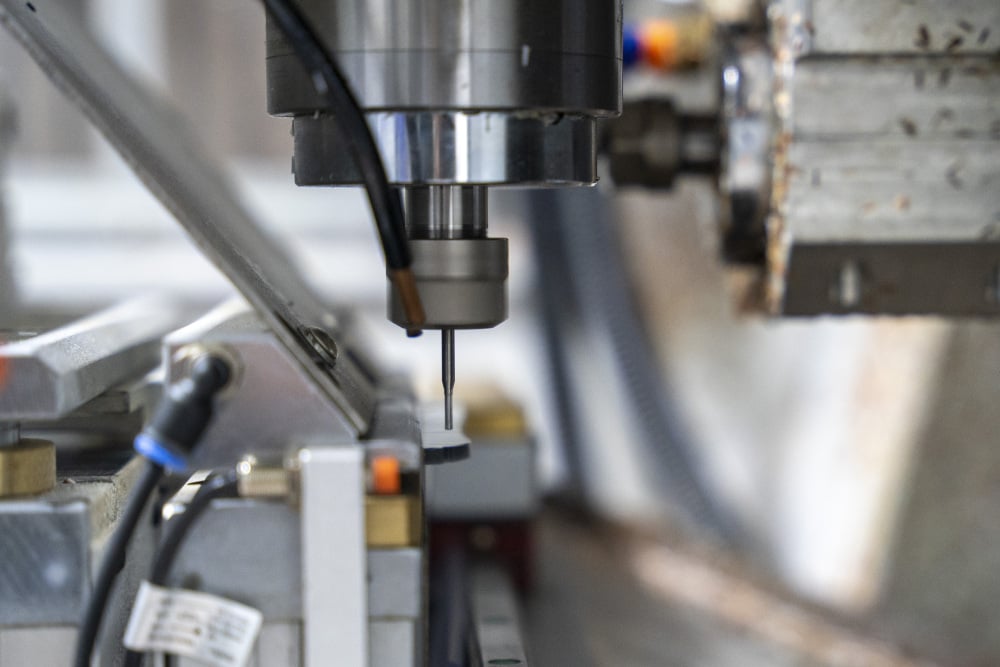 Machine outil numerique permettant la découpe des branches de lunettes à l'aide d'un tour industriel spécialisé au sein de l'usine de l'entreprise CMS lunettes et plastiques à Oyonnax, dans la « Plastics Vallée ».