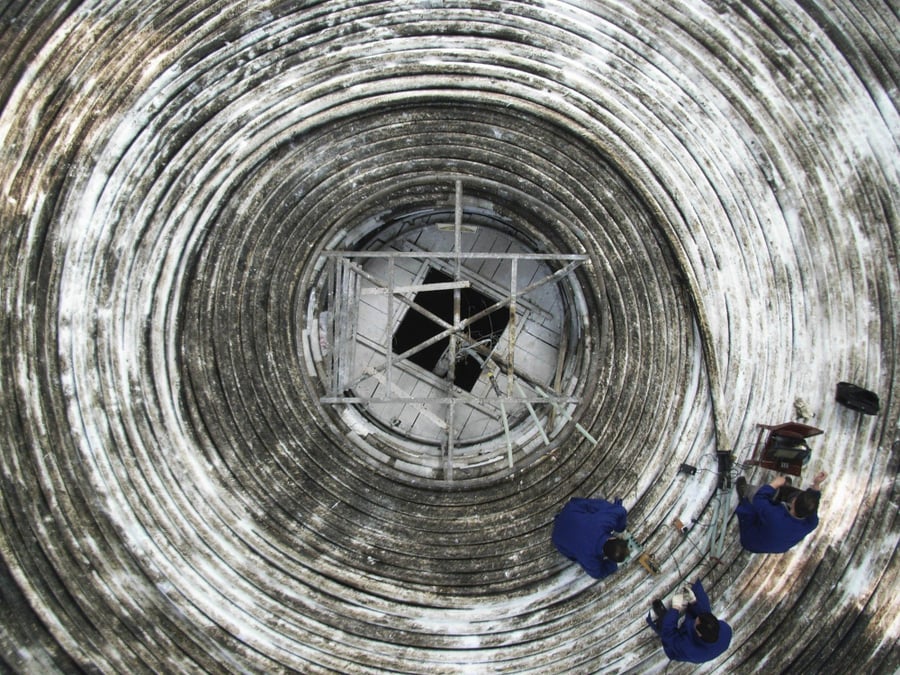 Des ouvriers examinent un câble sous-marin dans une usine de production.
