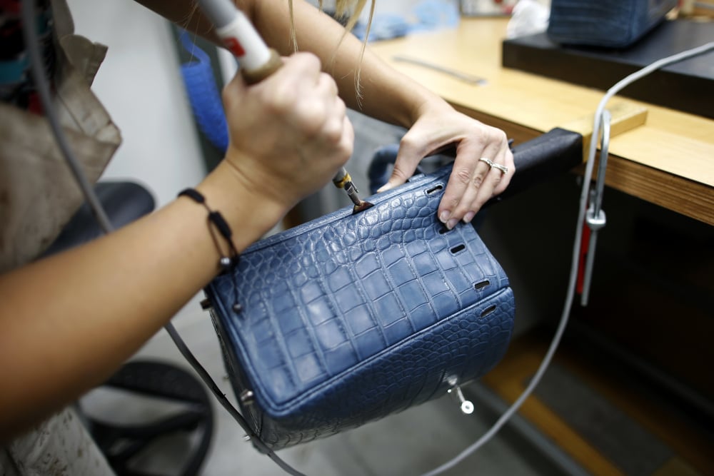 Une artisane travaille sur un sac Kelly à l'usine d'articles de luxe Hermès à Seloncourt (Doubs), le 4 octobre 2013. (Image d'illustration