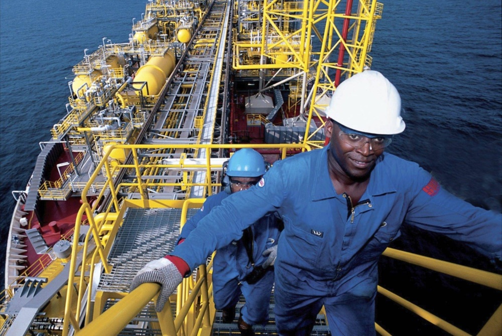 Travailleurs en tenue de sécurité sur une plateforme offshore.