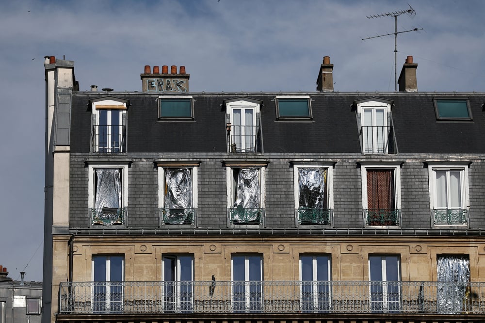 Les fenêtres d'un immeuble sont recouvertes de couvertures de survie pour se protéger du soleil alors que les températures grimpent à Paris.