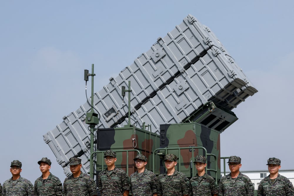 Des membres du groupe Hai Feng (Lame de mer) de la marine taïwanaise se tiennent devant un lance-missiles mobile Hsiung Feng III lors de la visite du président taïwanais Lai Ching-te à la base de Taoyuan, en réponse aux récents exercices militaires...
