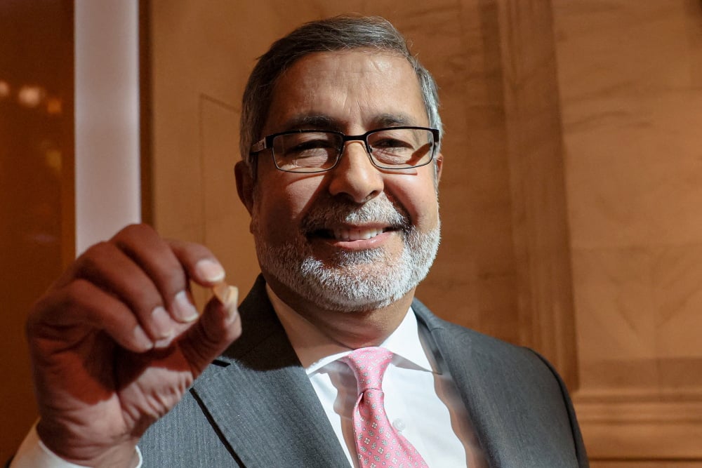 Sanjay Mehrotra, le PDG de Micron, tenant entre ses doigts une puce mémoire.